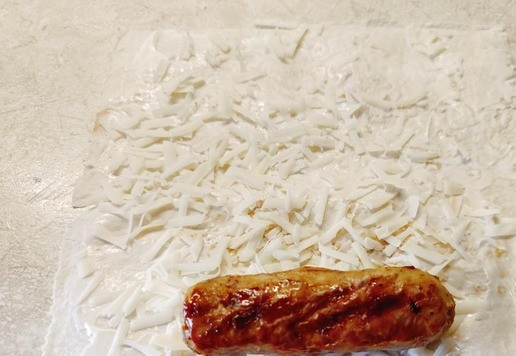 1. Этап. Пятачки из лаваша с сосисками: Лаваш разрезать на удобные кусочки. Смазать тонким слоем майонеза и присыпать натертым сыром. Положить поджаренную колбаску и завернуть рулетом. Нарезать на одинаковые шайбочки.