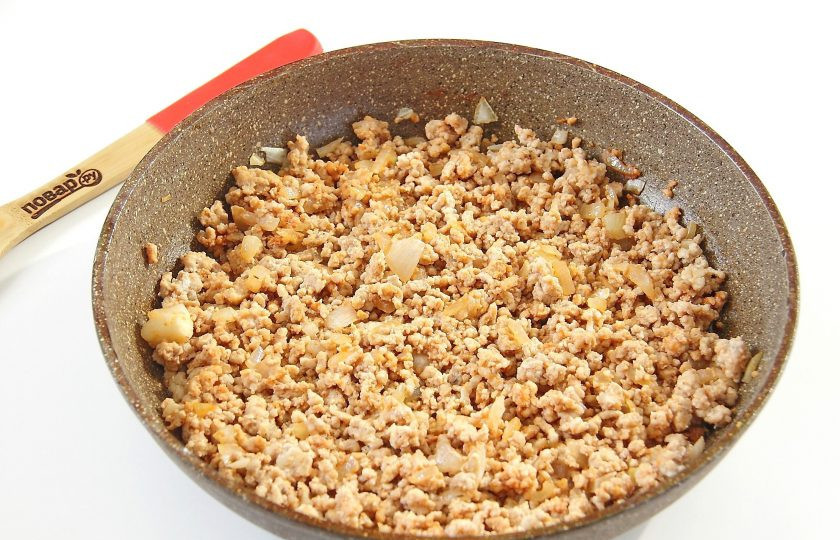 1. Этап. Баклажаны с мясом и овощами: Обжарьте лук до мягкости, добавьте фарш, томатную пасту, соль и специи. Готовьте все вместе, периодически помешивая, около 5-7 минут.