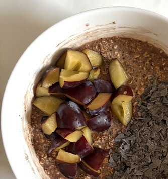 1. Этап. Запечённая овсянка со сливой: Добавить тёртый шоколад и 4 нарезанные сливы, перемешать.