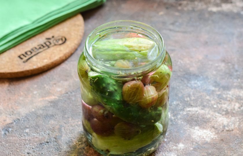 1. Этап. Огурцы с крыжовником на зиму: Залейте огурцы крутым кипятком. После прикройте горлышко крышкой и оставьте банку на 10 минут в покое.