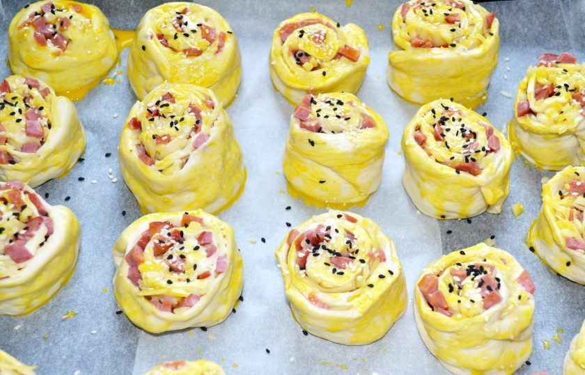 1. Этап. Булочки с колбасой и сыром в духовке: Смажьте булочки взбитым желтком и по желанию присыпьте кунжутом или сушеными травами. Отправьте в разогретую до 190 градусов духовку.