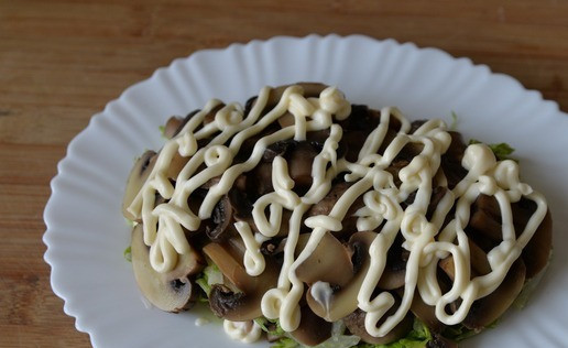 1. Этап. Салат Княжий град: На капусту кладём оставшиеся порезанные маринованные шампиньоны. Наносим полоски майонеза.