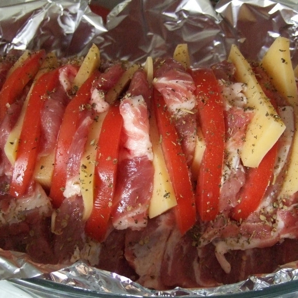 1. Этап. Свинина в духовке: Теперь в сделанные нами надрезы добавляем по паре пластинок чеснока, по пластинке сыра и помидора. Солим, перчим все еще раз.