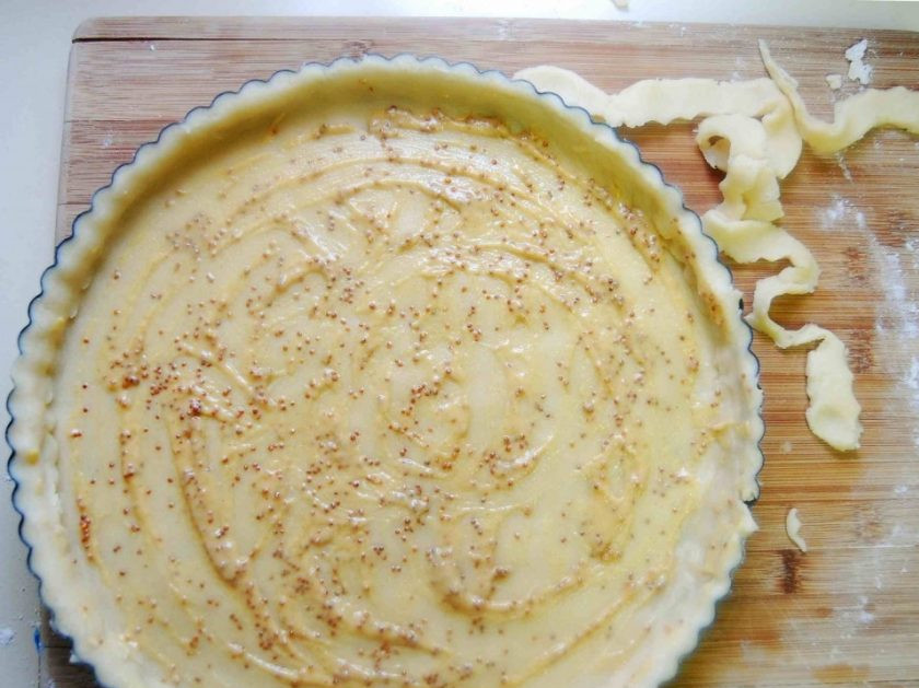 1. Этап. Тарт с помидорами и сыром: 2. Замешайте песочное тесто. Выложите его в круглую форму для выпечки, сделав бортики. Смажьте дно горчицей.