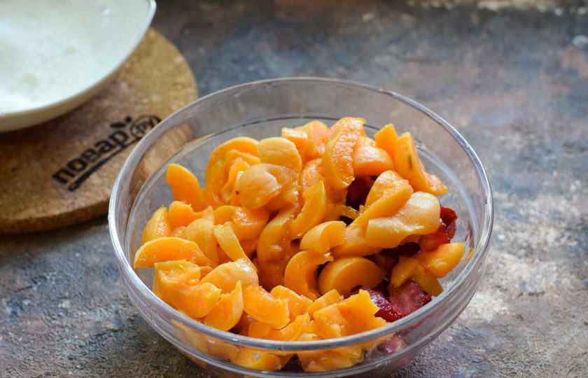 1. Этап. Пирог с абрикосами и клубникой в лаваше: Клубнику вымойте, удалите хвостики. Нарежьте клубнику небольшими кубиками. Также вымойте абрикосы, удалите косточки и нарежьте мякоть небольшими кусочками.