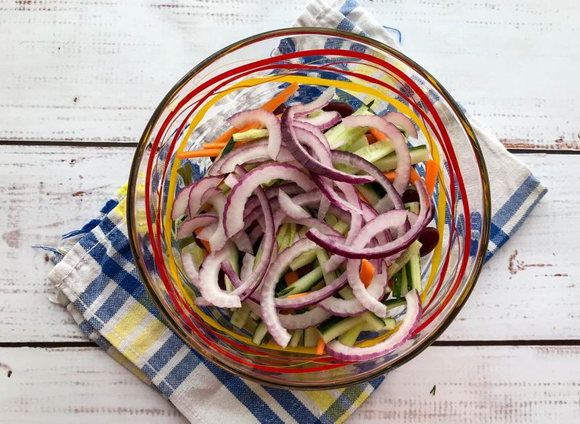 1. Этап. Салат с фасолью и морской капустой: Лук очистите от шелухи и нарежьте полукольцами. Огурец нарежьте соломкой.