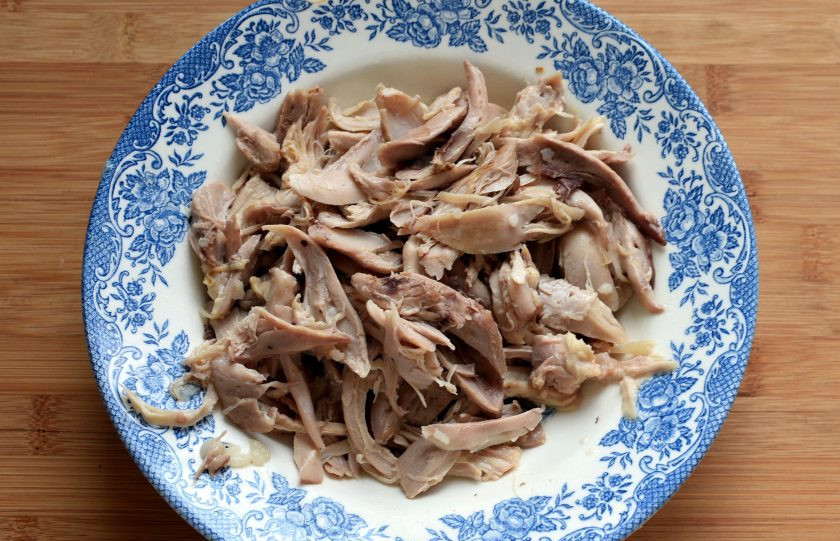 1. Этап. Филиппинский Арроз Кальдо: Выньте курицу, снимите мясо с костей и разберите его на волокна. Верните курицу в суп. Посолите и поперчите по вкусу, хорошо перемешайте и дайте постоять минут 5.