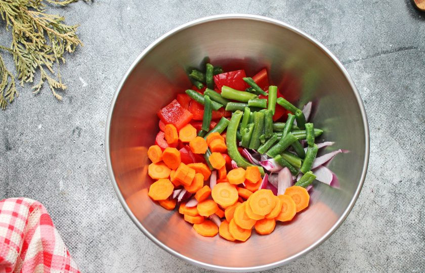 1. Этап. Овощное рагу с брокколи и баклажанами: Морковь порежьте кружочками, замороженную фасоль обдайте кипятком и выложите все в миску.