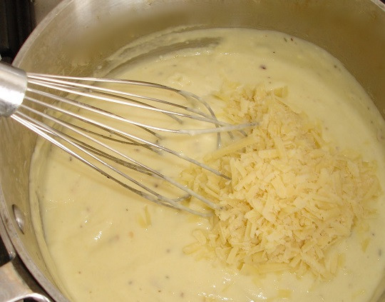 1. Этап. Лазанья с брокколи: 4. Яично-молочную смесь влить тонкой струйкой в соус и, активно перемешивая, довести до однородности. Соус должен немного увариться. Сыр натереть на терке и половину добавить в соус. Все тщательно перемешать и снять с огня.