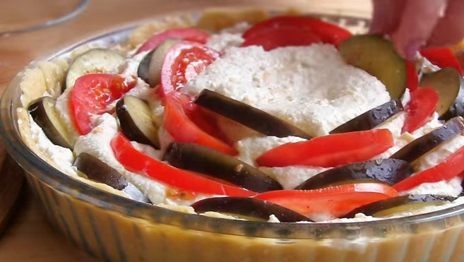 1. Этап. Творожный пирог с баклажанами: 7. Начинку выложите в тесто. Баклажаны и помидоры, нарезанные полукольцами, чередуя, выложите ребром в начинку. Смажьте пирог маслом, в котором мариновались баклажаны.