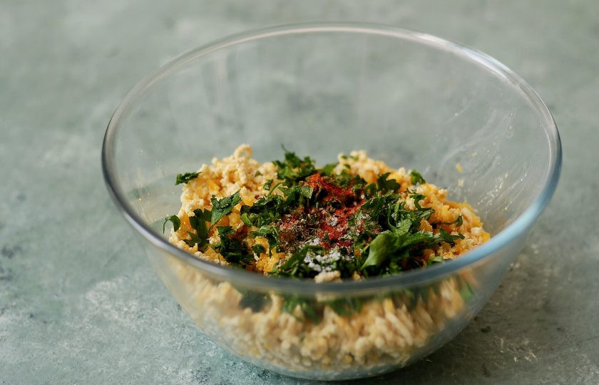 1. Этап. Котлеты из тыквы на пару: Добавьте мелко порубленную петрушку, специи, соль и перец. Перемешайте.