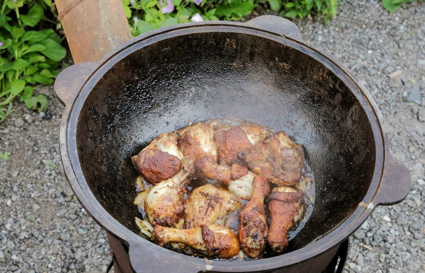 1. Этап. Куриные окорочка в казане на костре: Когда лук приобретёт золотистый оттенок, выложите сверху обжаренные кусочки мяса. Лук должен послужить своеобразной овощной 