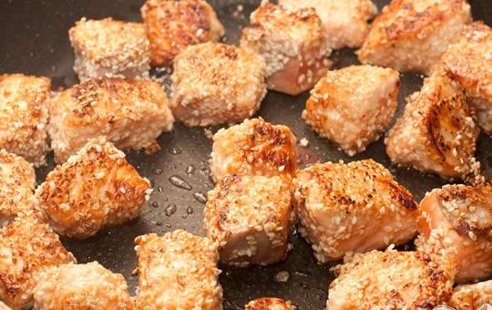 1. Этап. Лосось в кунжуте на подушке из цуккини: 3. Приготовим сковороду и выкладываем кусочки рыбы так, чтобы между рыбными кусочками оставалось пространство. До золотистого цвета со всех сторон равномерно обжариваем кусочки рыбы. Затем на время рыбу отставим в сторону.