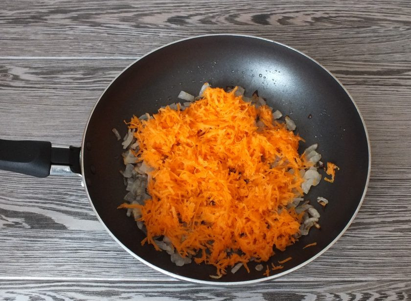 1. Этап. Скумбрия фаршированная с желатином и яйцом: Добавьте в сковороду с луком еще столовую ложку масла, натертую на мелкой терке морковь и обжарьте все вместе.