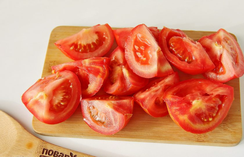 1. Этап. Баклажанная икра с помидорами через мясорубку на зиму: Помидоры нарежьте на 4 части.