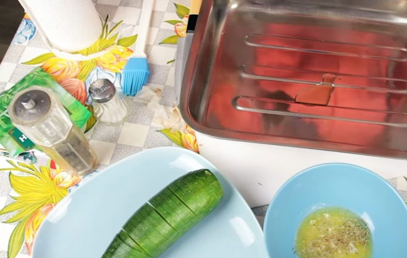 1. Этап. Запеченный цукини с пармезаном: 3. Противень для запекания смажьте оливковым маслом, выложите на него подготовленный цукини и смажьте растопленным сливочным маслом со специями (немного заправки оставьте).