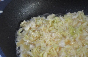 1. Этап. Сосиски в капусте: Взбейте яйца с солью и перцем. Капусту отожмите, смешайте с крахмалом, а затем с яичной массой. Разделите капусту с яйцами на 4 равные части. Выложите одну часть капусты на сковороду с маслом, разровняйте, придавая примерно форму прямоугольника. Поджарьте до румяной корочки только с одной стороны, примерно 1,5 мин.