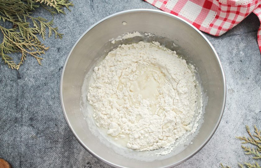 1. Этап. Пирог на кефире с черникой: Муку смешайте с разрыхлителем, просейте в кефирную массу и перемешайте до однородного теста.