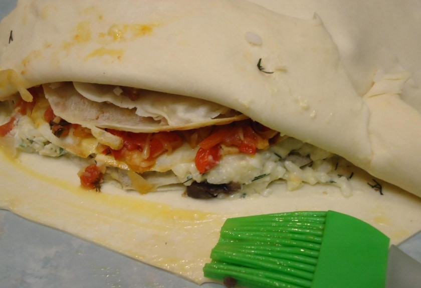 1. Этап. Курник из бездрожжевого теста: 17. Раскатываю второй пласт теста и накрываю им пирамиду из блинов, смазываю края желтком и защипываю.