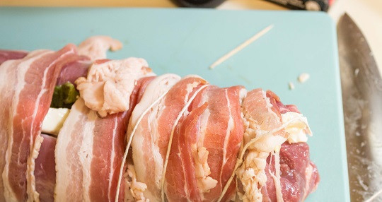 1. Этап. Рулет с плавленым сыром: 5. Теперь свинину нужно аккуратно свернуть и обернуть полосками бекона. Таким образом, мясо будет еще более сочным и нежным. Также понадобится плотная веревка, которой нужно будет обвязать рулет.