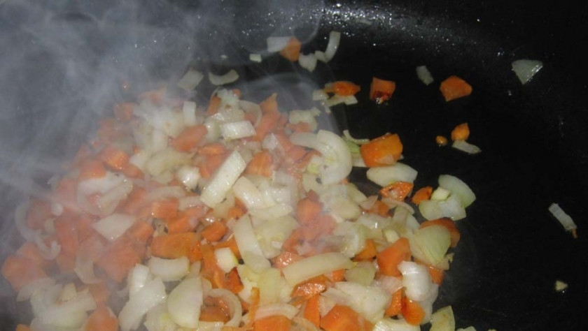 1. Этап. Мясные пальчики: Очистите репчатый лук и морковь. Лучок нашинкуйте ножом, а морковку натрите на терке. Обжарьте до золотистого цвета овощи на отдельной сковороде в небольшом количестве рафинированного подсолнечного масла.