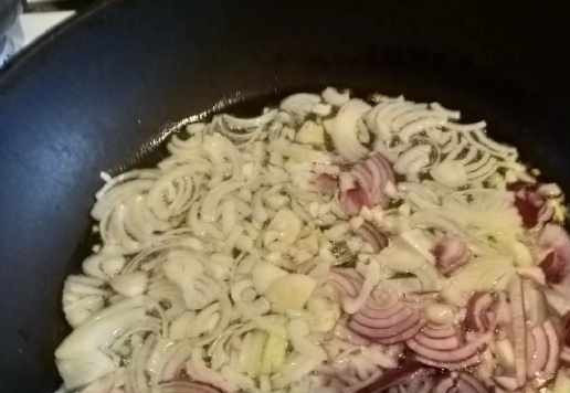 1. Этап. Куриная печень с грибами и сметаной: Лук нарезать четвертькольцами, чеснок измельчить ножом. Обжарить лук на растительном масле до лёгкой золотистости.