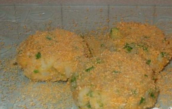 1. Этап. Рыбные котлеты по-домашнему: 3. Положить рыбу, картофель, яйцо, зеленый лук, петрушку, соль и перец, а также три ст.л. панировочных сухарей в кухонный комбайн и перемолоть. Из получившееся смеси слепить три круглых котлеты. Обвалять их в оставшихся сухарях.