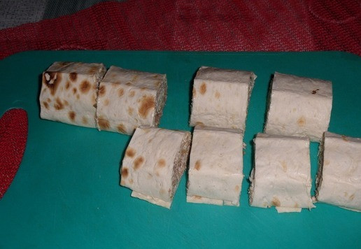 1. Этап. Рулет из лаваша Новогодний: Затем вынимаем рулет из пакета и нарезаем на кусочки.