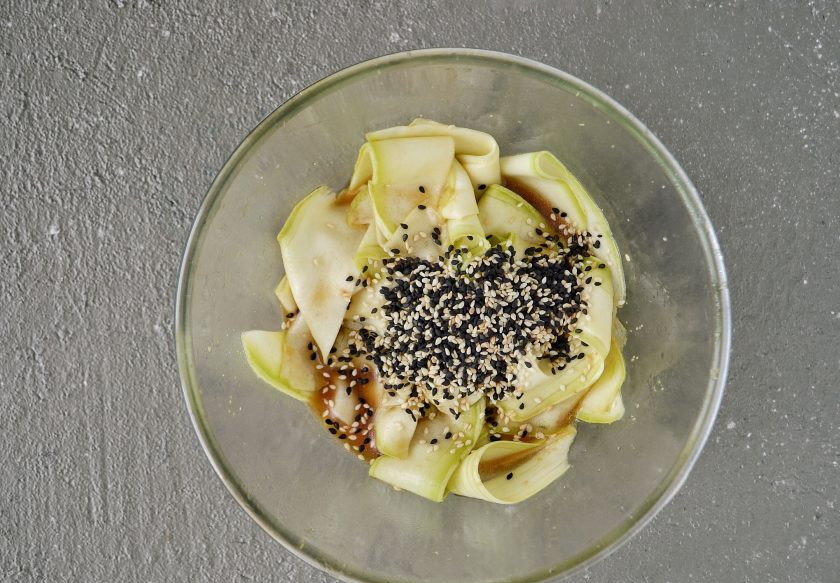 1. Этап. Кабачок с кунжутом: Заправьте порезанный кабачок соусом, перемешайте. Затем добавьте кунжут и ещё раз перемешайте.