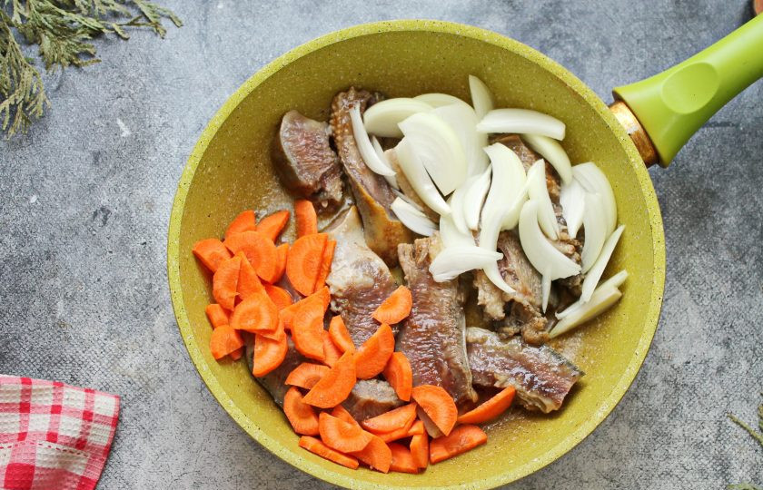 1. Этап. Говяжьи губы с овощами: Репчатый лук порежьте полукольцами, морковь порежьте кружочками или полукольцами. В сковороду налейте растительное масло и разогрейте на среднем огне. Выложите порезанные губы и немного обжарьте с двух сторон. Добавьте в сковороду репчатый лук и морковь, обжарьте в течение 10 минут, перемешивая.