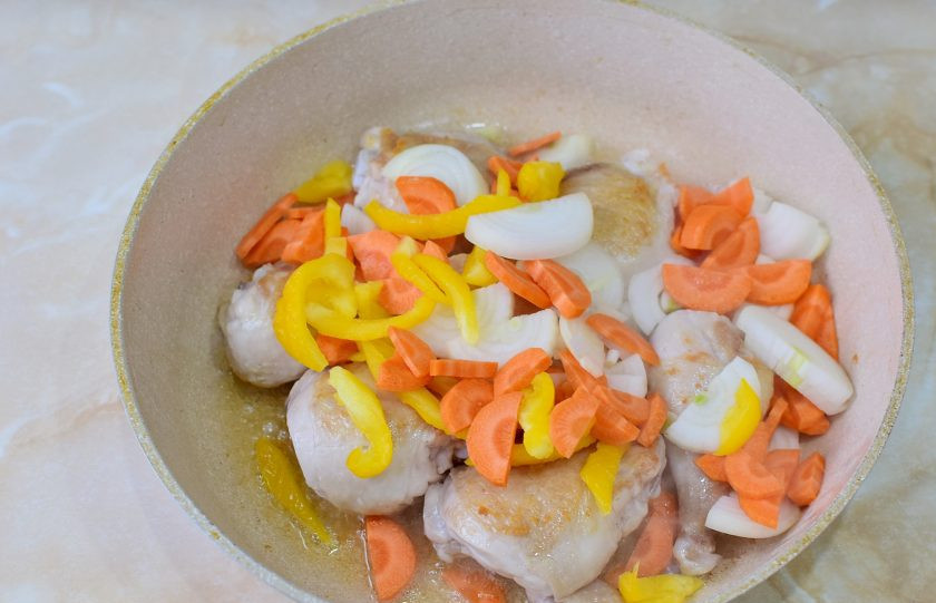 1. Этап. Цыпленок по-охотничьи: В сковороду выложите лук, морковь и перец. Перемешайте. Обжарьте все вместе 3-5 минут. От овощей появится характерный аромат.