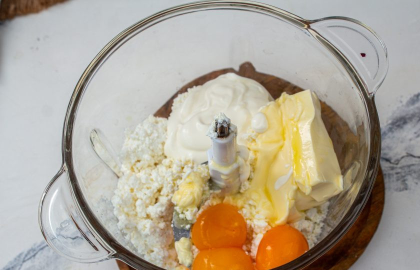 1. Этап. Творожно-шоколадная пасха заварная: В чашу блендера положите творог, мягкое сливочное масло, куриные яйца и сметану. Измельчите массу до однородности.