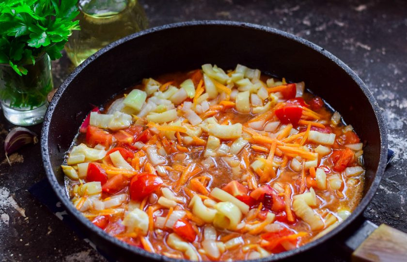 1. Этап. Салат Украинский на зиму: Добавьте к овощам томат, тушите 25 минут на небольшом огне.