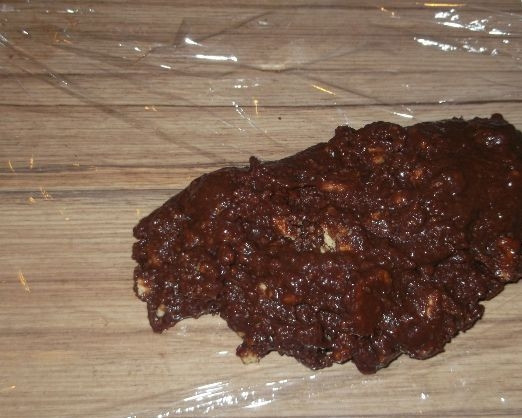 1. Этап. Колбаса из печенья: 6. Берем пищевую пленку, выкладываем в нее полученную шоколадную массу. Распределяем по длине, формируя 