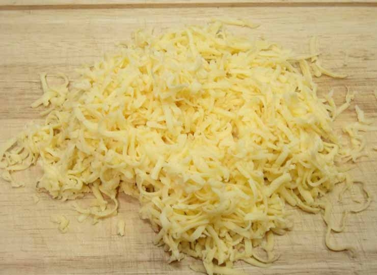 1. Этап. Мясо по-чешски: 3. Самое время взяться за начинку. Для этого необходимо натереть сыр. Чеснок очистить и выдавить через пресс. Зелень измельчить. Все отправить в одну миску и тщательно перемешать.