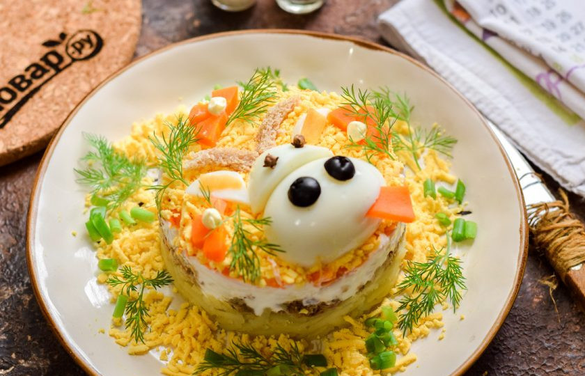 1. Этап. Салат Мимоза на Новый год Быка 2021: Выложите заготовку поверх салата и украсьте зеленью.