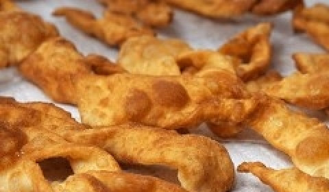 1. Этап. Воздушный хворост на кефире: 5. В чугунке или в глубокой сковородке разогрейте до кипения масло. Проследите, чтобы оно не горело. Его количество должно быть таким, чтобы заготовка хвороста покрывалась полностью. Выкладывайте заготовки из теста шумовкой в небольших количествах. Обжаривайте с двух сторон до устойчивой румяной корочки.