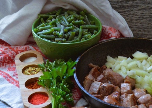1. Этап. Гуляш со стручковой фасолью: Мясо нарезать кубиком, 2*3 см. На разогретом растительном масле телятину обжарить до румяности, огонь выше среднего, 5-7 минут. Добавить резаный репчатый лук, жарить на среднем огне, перемешивая, 3-5 минут.