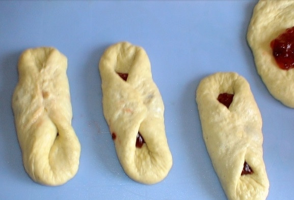 1. Этап. Латвийские булочки с повидлом: Сформируйте булочки, складывая в центр лепёшек по 2 ч. ложки повидла. Концы по бокам скрепите в центре. Оставьте изделия ещё на 50 минут.