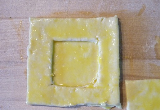 1. Этап. Слойки Слоеные сокровищницы: Взбейте яйцо. Равномерно смажьте квадратики без отверстия яйцом, выложите на них квадратики с отверстием и тоже их смажьте яйцом... Отдельно смажьте крышечки. Выпекать при 190 градусах 8-10 минут до золотистой корочки. Остудить.