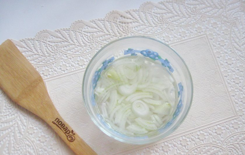 1. Этап. Салат с консервированной горбушей и грибами: Лук очистите, помойте и нарежьте полукольцами. Выложите в мисочку и залейте горячей водой. Через 5-6 минут воду слейте. После этого лук потеряет горечь.