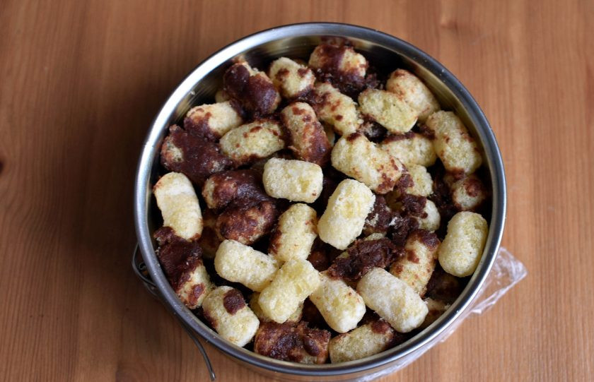 1. Этап. Торт из кукурузных палочек: Выложите массу в разъемную форму, застеленную пищевой пленкой и очень хорошо утрамбуйте. Дайте остыть в течение часа. Можно убрать торт в холодильник, но это не обязательно, достаточно просто охладить.