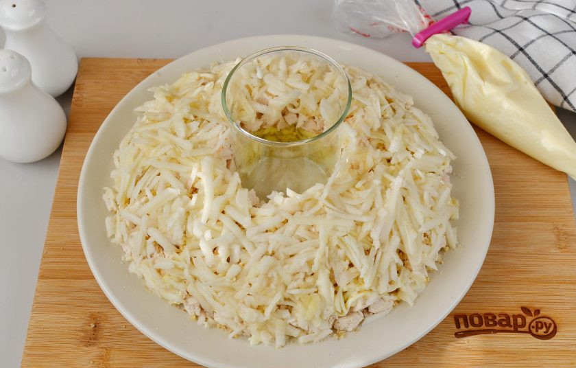 1. Этап. Салат Гранатовый браслет с курицей и яблоком: С яблок снимите кожуру, натрите на крупной терке, сбрызните лимонным соком. Если яблоки кисловатые, то не нужен лимонный сок. Распределите тертое яблоко. Этот слой смазывать не нужно.