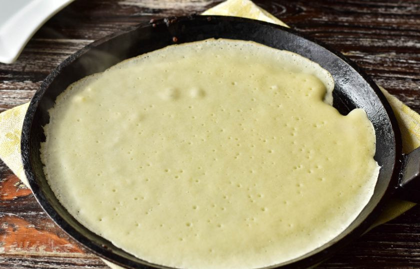 1. Этап. Заварные блины на кефире и молоке: Налейте тесто на сковороду, переверните ее так, чтобы оно по ней полностью распределилось.