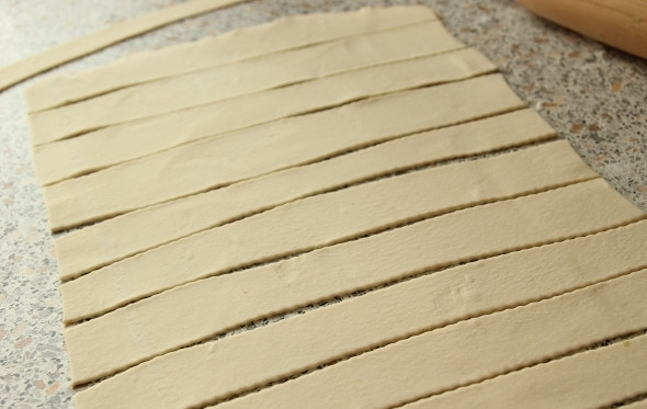 1. Этап. Слоеные трубочки с белковым кремом: Заранее включите духовку, чтобы она хорошо прогрелась. Теперь приступайте к изготовлению заготовок для трубочек. Для этого тесто раскатайте потоньше и нарежьте полосами по 2-2,5 см.