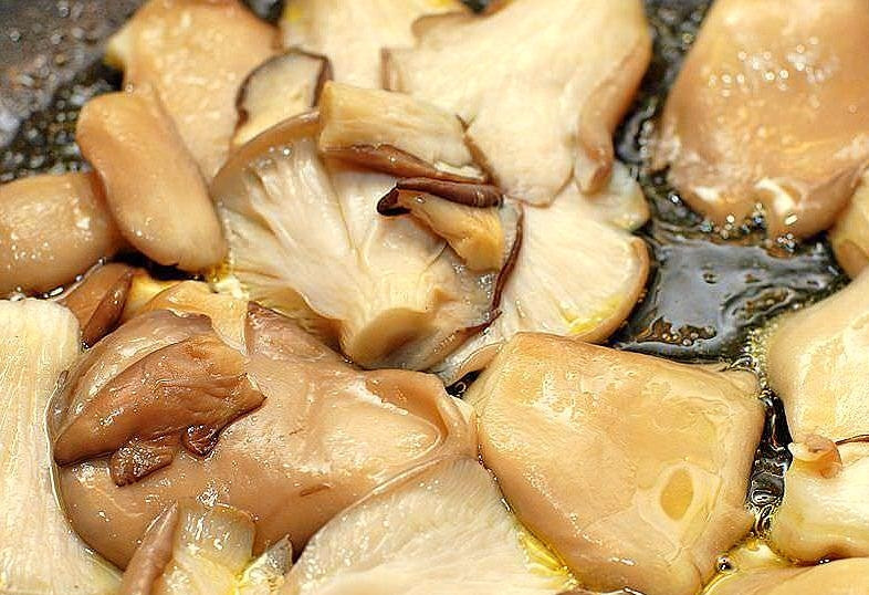 1. Этап. Вешенки, жареные с картошкой: В одной из двух заранее подготовленных сковород разогреть пару столовых ложек растительного масла. Выложить вешенки, накрыть крышкой. Спустя пару минут грибы дадут столько жидкости, что будут в ней плавать - в этот момент надо открыть крышку, и пусть она себе выпаривается. Когда сковорода станет практически сухой, добавить немного масла и обжаривать вешенки на сильном огне, постоянно помешивая, до румяного цвета.