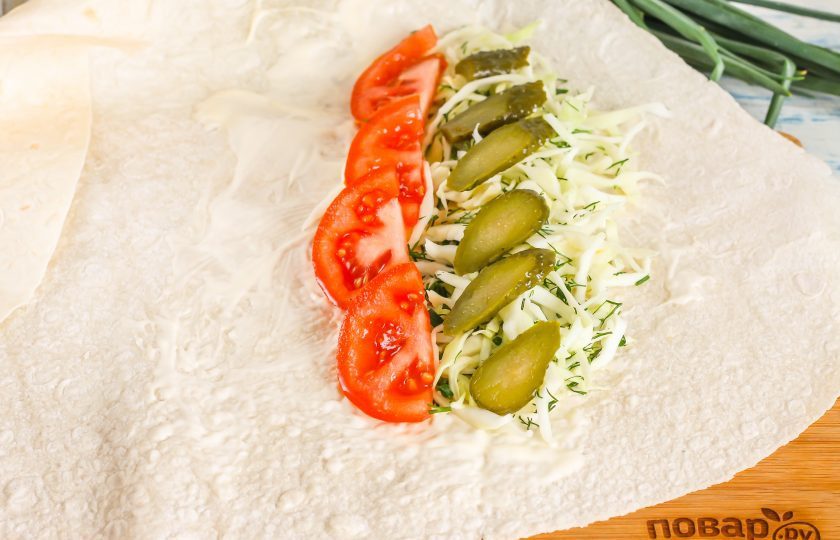 1. Этап. Денеры в лаваше: Нарежьте ломтиками корнишоны или маринованные огурцы, выложите на капусту.