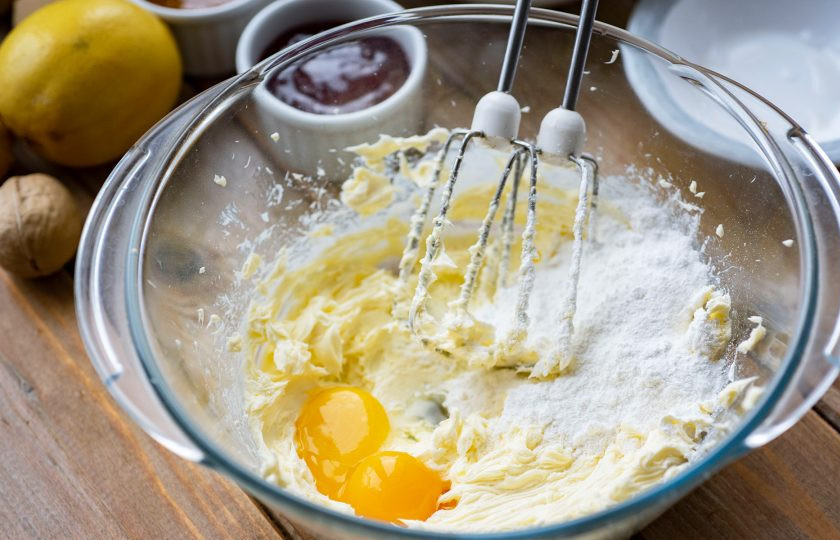 1. Этап. Австрийское Линцерское печенье: Ко взбитому маслу добавьте сахарную пудру и яичные желтки. Взбивайте миксером эти ингредиенты до получения однородной смеси.