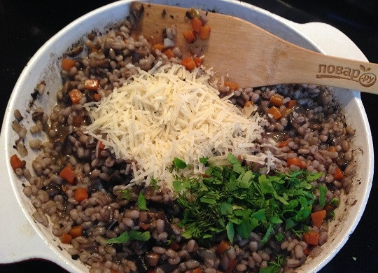 1. Этап. Перловая каша с грибами и беконом: 8. В конце приготовления, когда перловка уже готова, максимально выпарим жидкость, помешивая кашу. Добавим мелко натертый твердый сыр и нарезанную зелень. Перемешиваем.