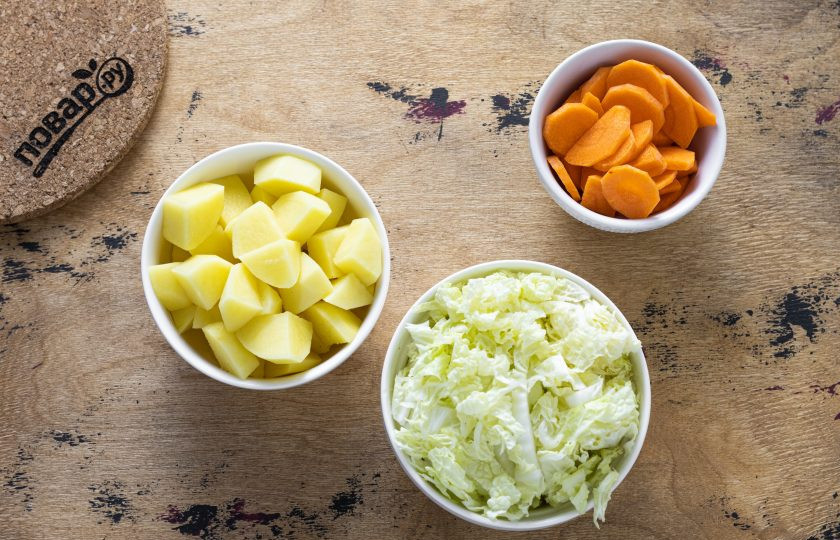 1. Этап. Рагу из кимчи: Картофель помойте, очистите и нарежьте кубиками среднего размера. Пекинскую капусту тонко нашинкуйте. Морковь очистите, нарежьте тонкими дольками.